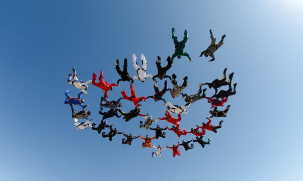 Skydiving group formation in a low-angle view.