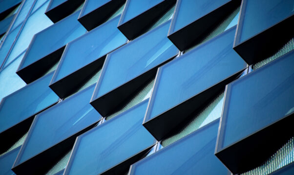 Angular abstract glass rectangles on the side of an office building.