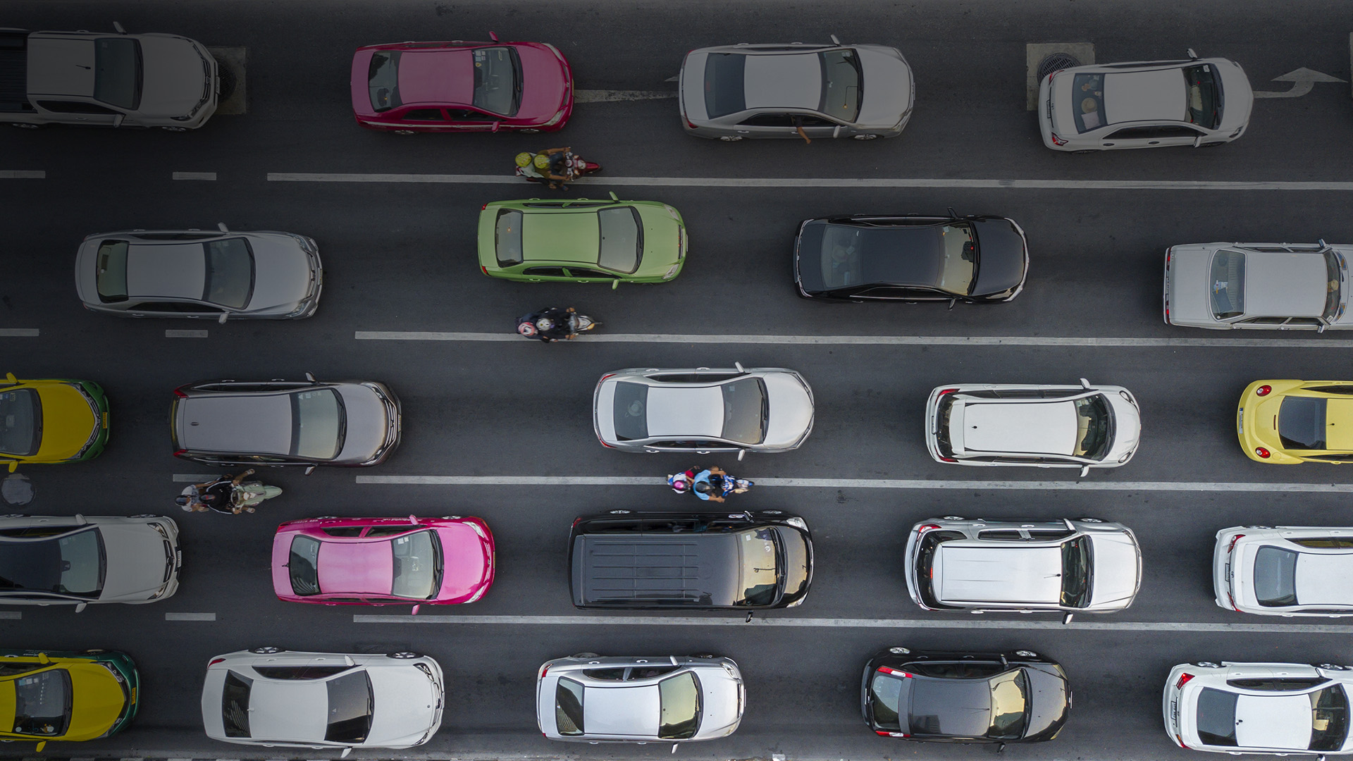 Aerial view of highway lanes stacked with cars of different colours.